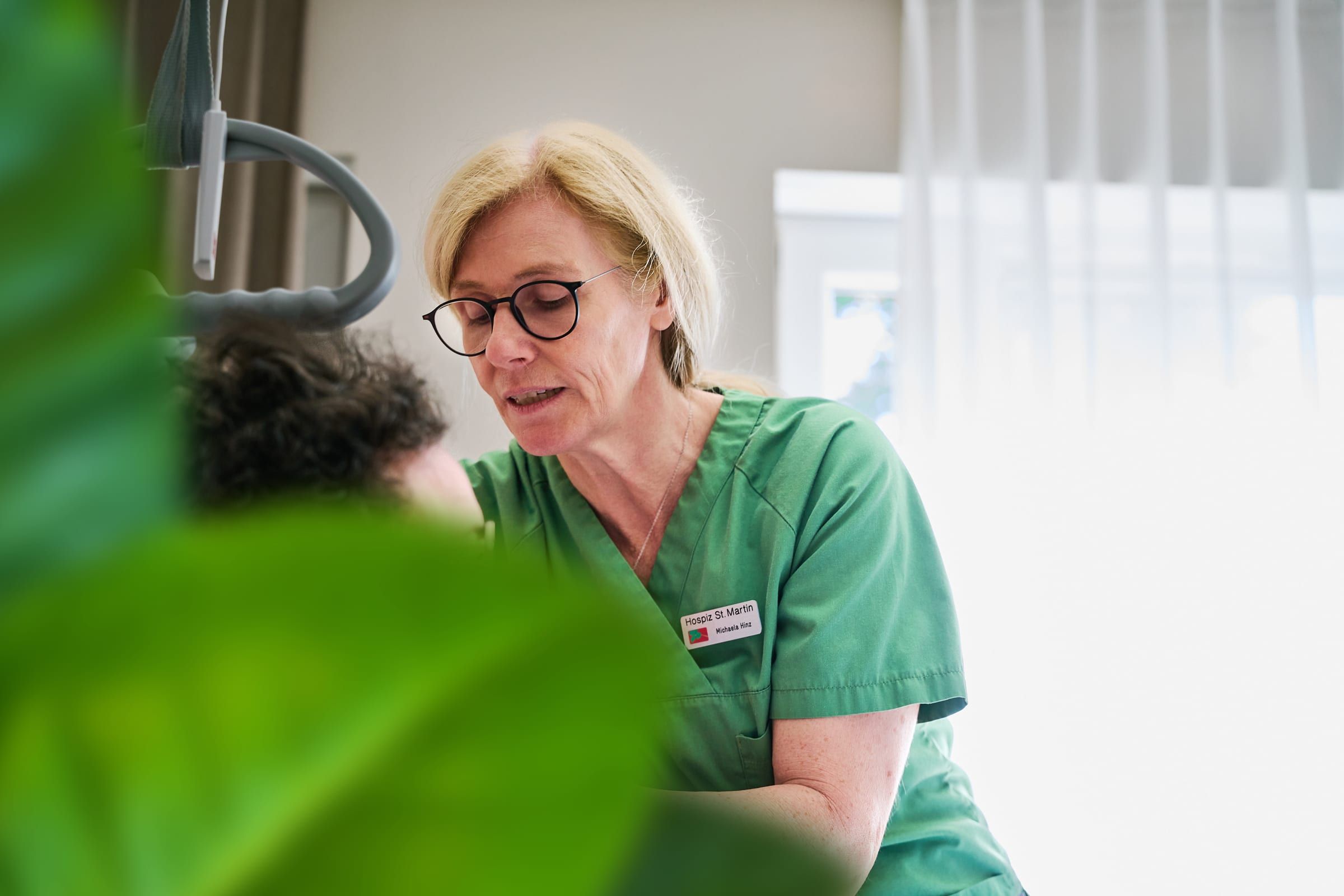 Michaela Hinz im Gespräch mit einer Gästin am Bett im stationären Hospiz St. Martin