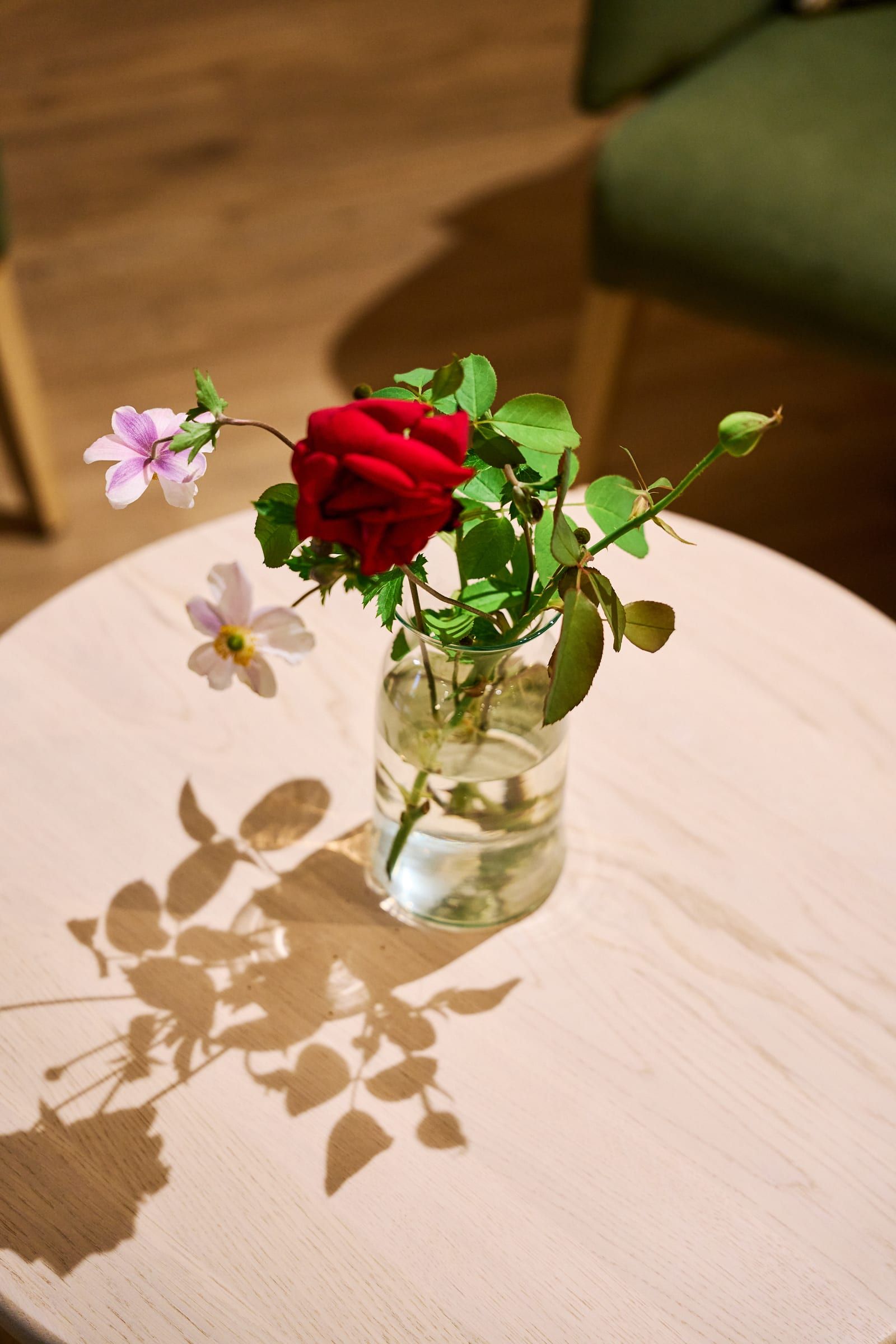 Rose und Herbstanemone in einer Vase auf einem Beistelltisch